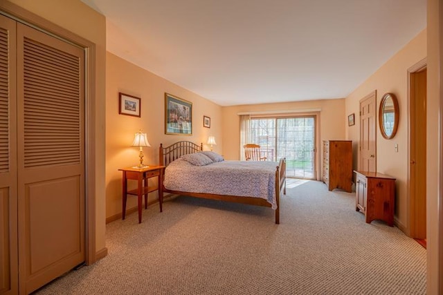 bedroom with access to outside, baseboards, light carpet, and a closet