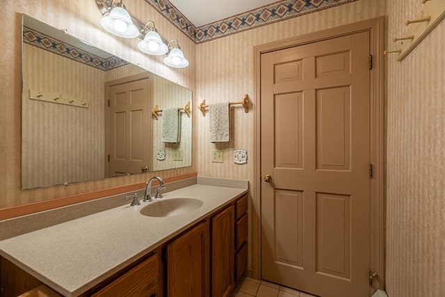 bathroom with wallpapered walls, tile patterned flooring, and vanity