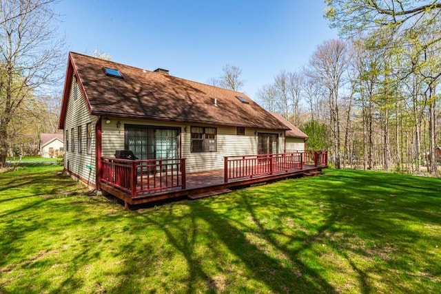 back of property featuring a lawn, a wooden deck, and a chimney