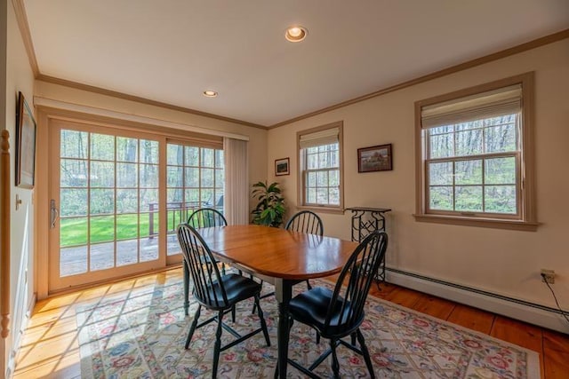 dining room featuring light wood-style floors, ornamental molding, baseboard heating, and recessed lighting