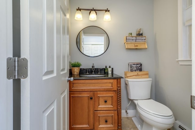 bathroom with vanity, toilet, tile patterned floors, baseboards, and a baseboard radiator