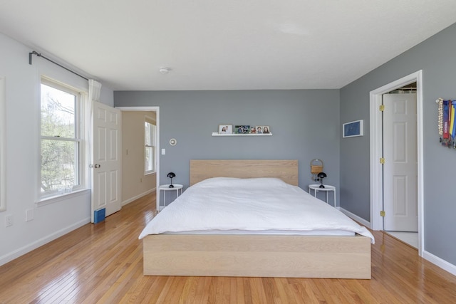 bedroom with baseboards and light wood-style flooring
