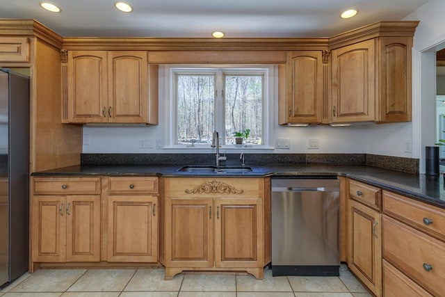 kitchen with appliances with stainless steel finishes, a sink, brown cabinetry, dark stone counters, and recessed lighting