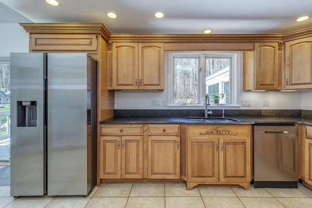 kitchen with brown cabinets, appliances with stainless steel finishes, a sink, recessed lighting, and light tile patterned floors