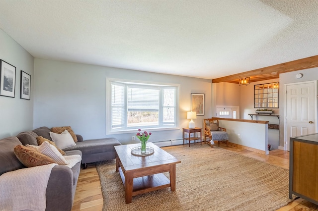 living room with a baseboard heating unit, an inviting chandelier, light wood-style flooring, and a textured ceiling