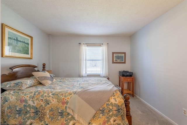 carpeted bedroom with a textured ceiling and baseboards