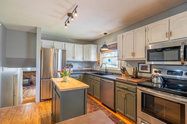 kitchen featuring wood counters, white cabinetry, appliances with stainless steel finishes, and a sink
