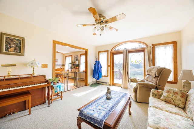 living room with carpet flooring, ceiling fan, and a baseboard heating unit