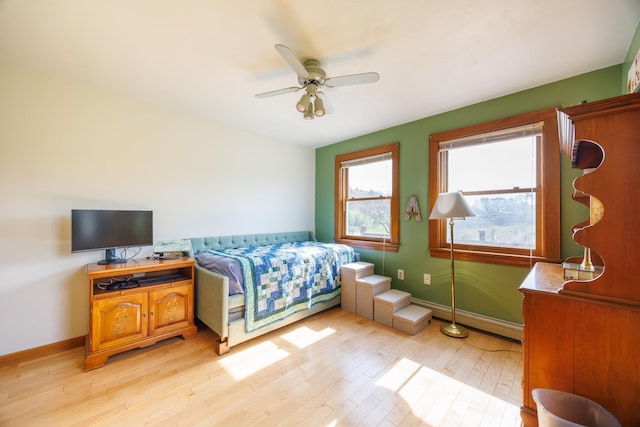 bedroom with light wood-style floors, baseboards, and ceiling fan