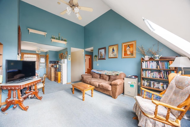living area with carpet, ceiling fan, a skylight, and high vaulted ceiling