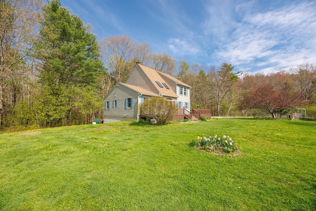 view of side of home with a deck and a lawn