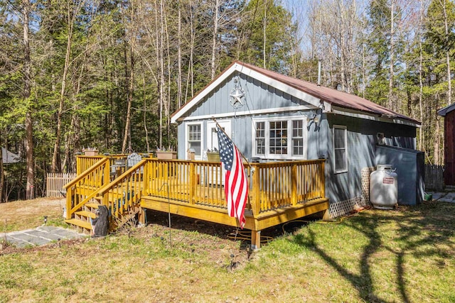 exterior space featuring a yard, board and batten siding, and a wooden deck