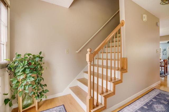 staircase featuring baseboards and wood-type flooring