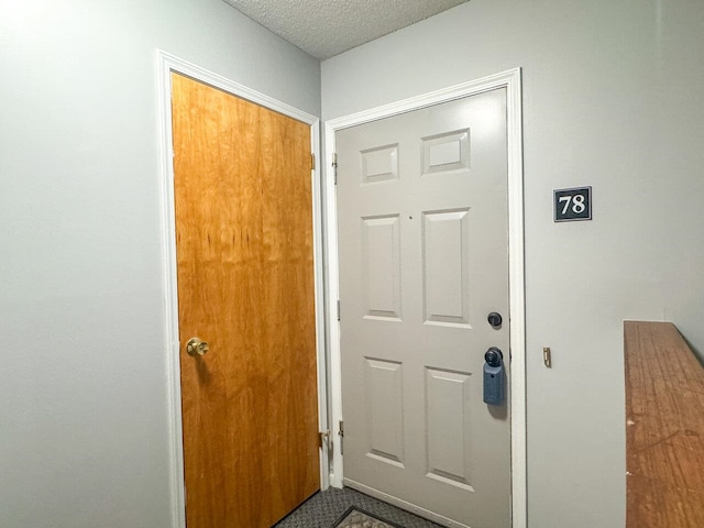 doorway with a textured ceiling