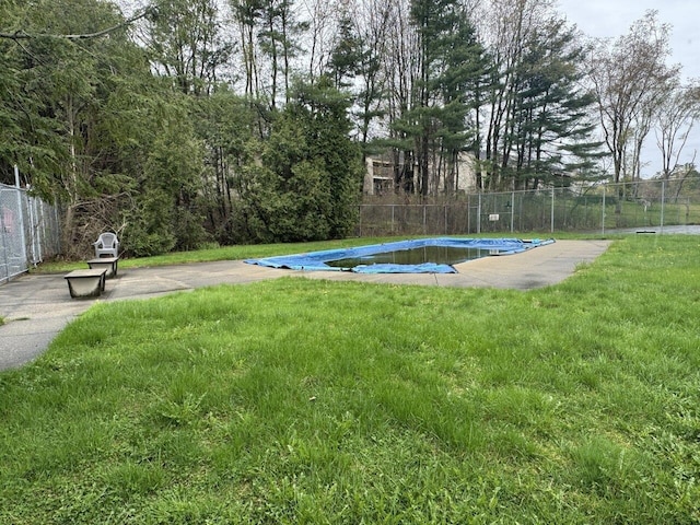 view of swimming pool with a lawn, a fenced in pool, and fence