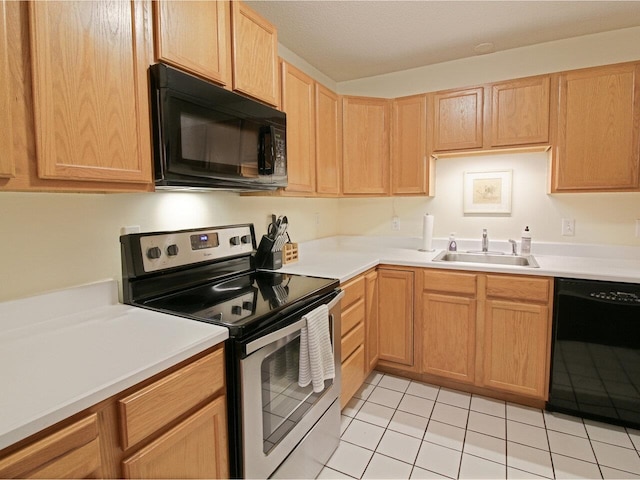 kitchen featuring light countertops, light tile patterned floors, black appliances, and a sink