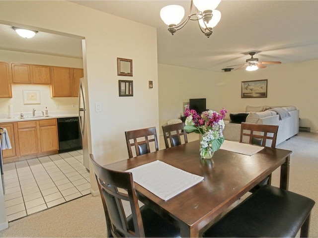 dining space featuring light colored carpet, light tile patterned floors, and ceiling fan with notable chandelier