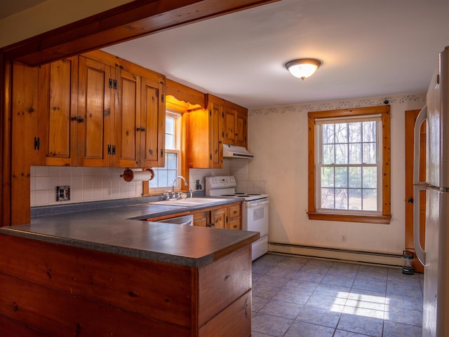 kitchen featuring under cabinet range hood, a baseboard radiator, white appliances, and brown cabinets
