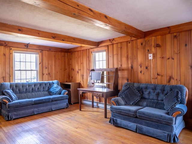 living room with plenty of natural light, baseboard heating, beamed ceiling, and light wood-type flooring