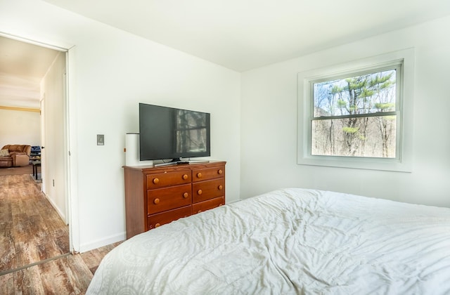 bedroom with wood finished floors and baseboards