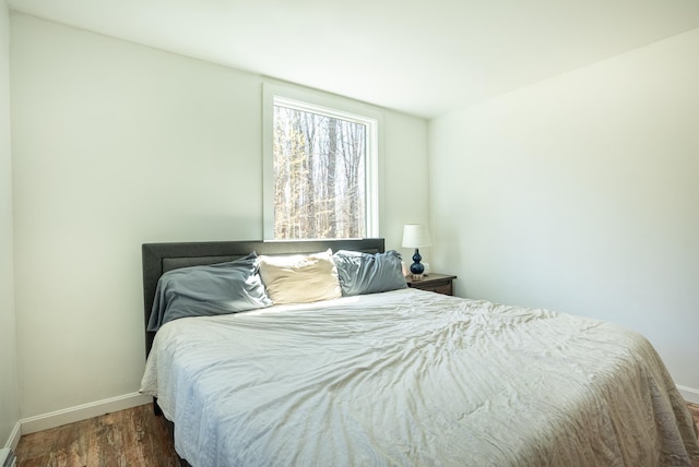bedroom featuring dark wood-style flooring and baseboards