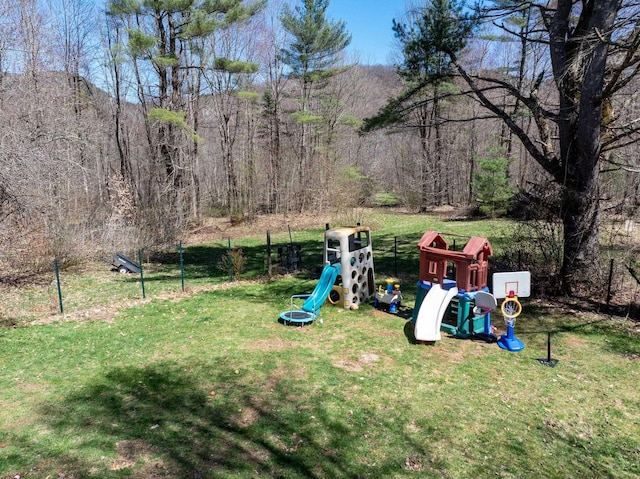 view of yard featuring a playground, a mountain view, and a view of trees