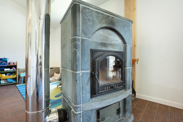 details with a wood stove, baseboards, and wood finished floors