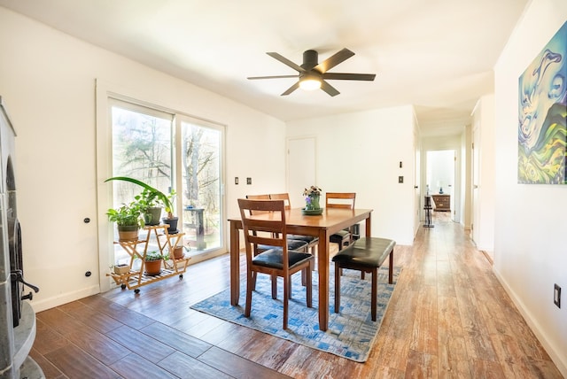 dining area with hardwood / wood-style flooring, baseboards, and a ceiling fan