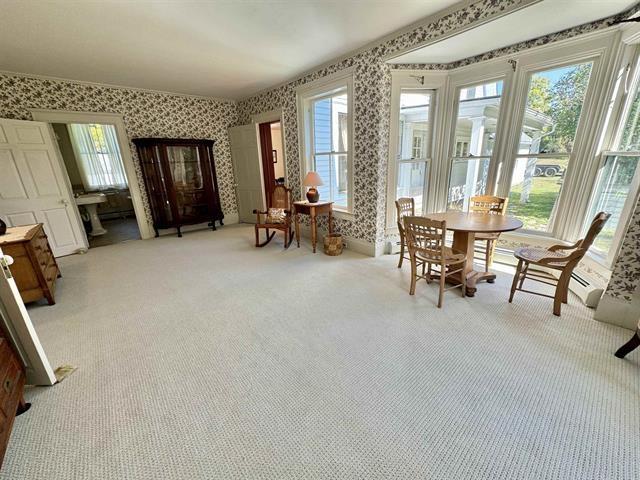 dining space featuring light carpet and wallpapered walls