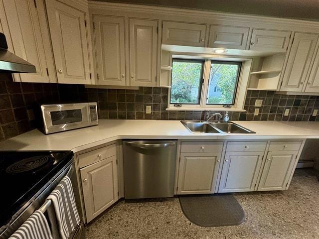 kitchen with open shelves, light countertops, appliances with stainless steel finishes, and a sink