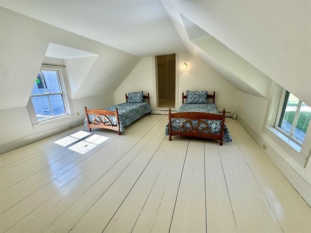 bedroom featuring multiple windows, lofted ceiling, and wood-type flooring