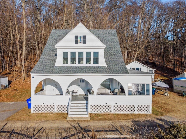 exterior space featuring a porch and roof with shingles