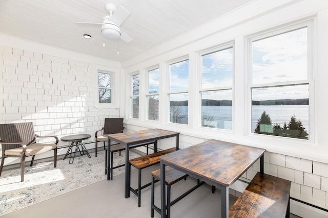 sunroom with a water view and baseboard heating