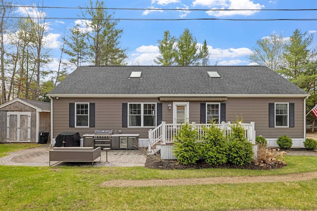 back of property with a storage unit, an outdoor structure, a patio, and a lawn