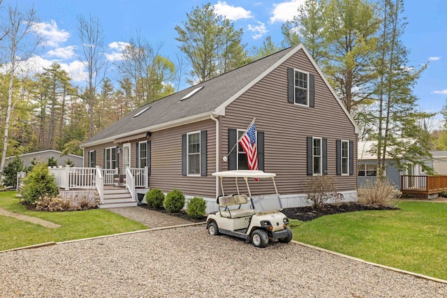 view of front of property with a wooden deck, a shingled roof, and a front lawn