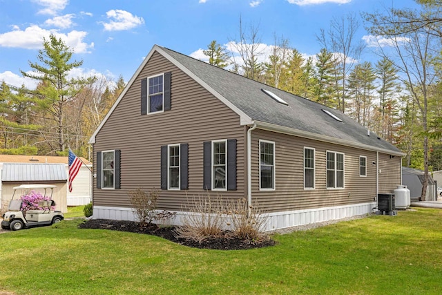 view of home's exterior with a lawn and roof with shingles