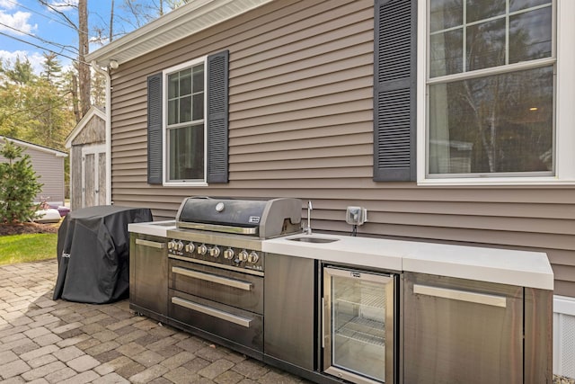 view of patio / terrace with a sink, wine cooler, grilling area, and an outdoor kitchen