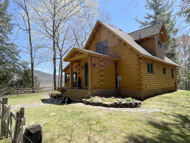 view of property exterior featuring a lawn, a mountain view, fence, log siding, and a shingled roof