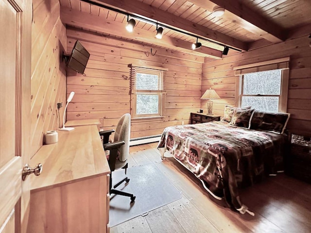 bedroom with hardwood / wood-style floors, rail lighting, wood walls, baseboard heating, and wooden ceiling