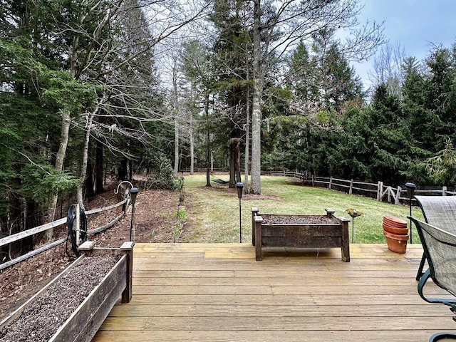 wooden terrace featuring a lawn and fence