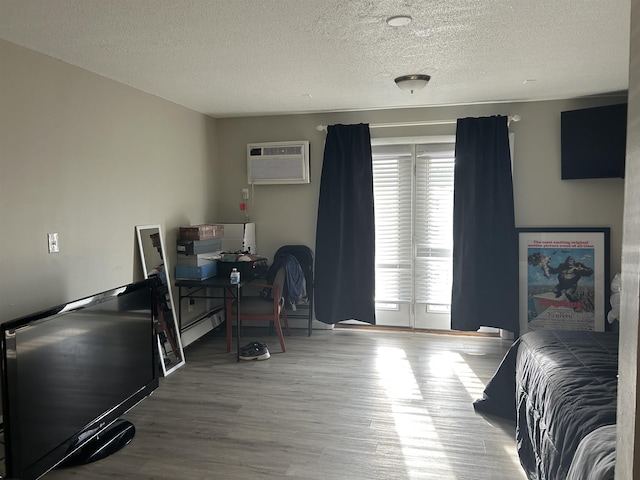 124 Mammoth Rd Unit 206, Hooksett, NH 03106 - bedroom featuring a wall mounted air conditioner, multiple windows, wood finished floors, and a textured ceiling