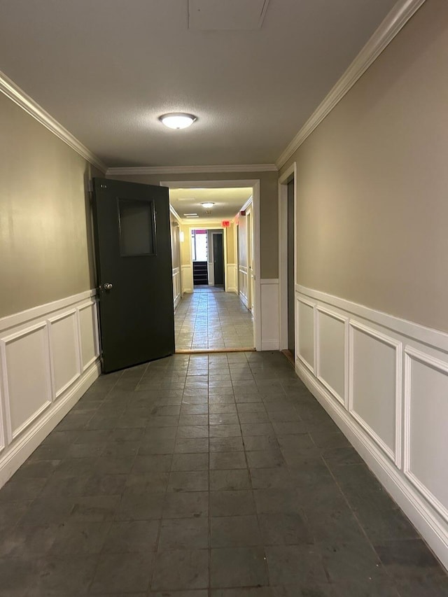 124 Mammoth Rd Unit 206, Hooksett, NH 03106 - hallway featuring crown molding, a decorative wall, dark tile patterned floors, and wainscoting