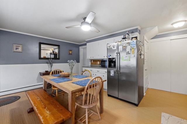 dining space with a ceiling fan, a baseboard radiator, light wood-style flooring, and crown molding