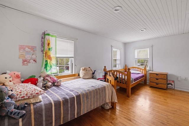 bedroom with wooden ceiling and light wood-type flooring