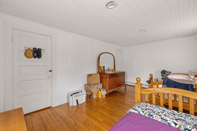 bedroom with a baseboard radiator, wood ceiling, and light wood-type flooring