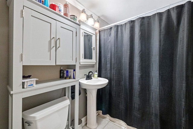 bathroom with toilet, tile patterned flooring, a shower with curtain, and a sink