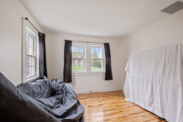 bedroom featuring baseboards, visible vents, and wood finished floors