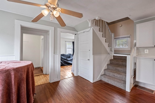 stairs with a ceiling fan, visible vents, and wood finished floors