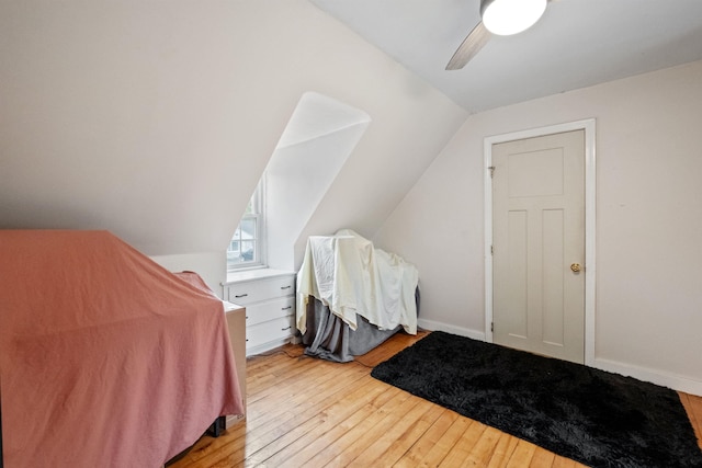 bedroom with lofted ceiling, baseboards, wood-type flooring, and a ceiling fan