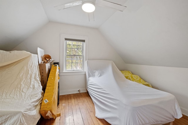 bedroom with lofted ceiling, hardwood / wood-style floors, a ceiling fan, and baseboards
